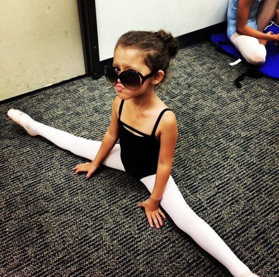Nola as a child in ballet attire wearing oversized sunglasses